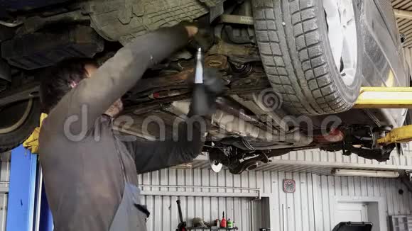 男汽车修理工带扳手在汽车修理厂工作视频的预览图