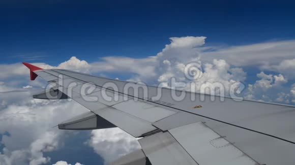 4K镜头飞机飞行在白云和蓝天上空飞行的飞机的翅膀窗外美丽的鸟瞰图视频的预览图