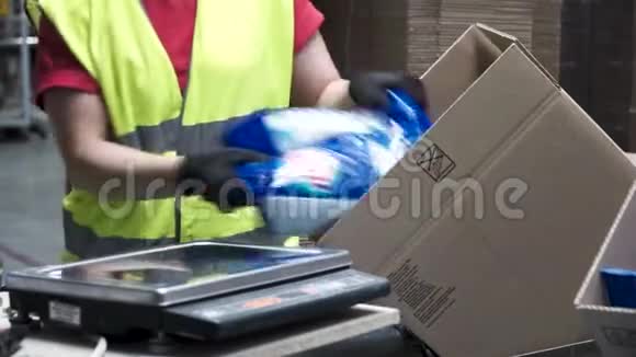生产工人在出口或出口前将包装好的产品放入纸板箱中的手的特写镜头视频的预览图