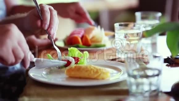 快乐的一家人在早餐煎蛋卷中有水果沙拉和一杯水1920x1080视频的预览图