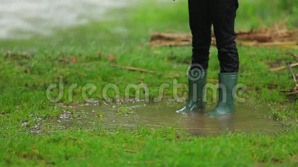 穿橡胶靴子的儿童站在水坑里视频的预览图