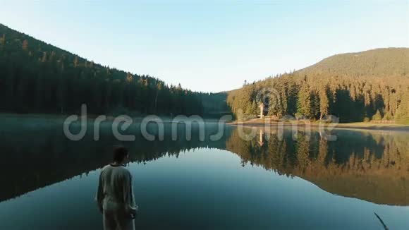 穿着刺绣衬衫的英俊的年轻人正看着风景如画的塞内维尔湖喀尔巴阡山的蜜月视频的预览图