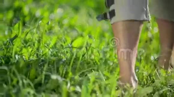 光着脚在阳光明媚的早晨草地上散步视频的预览图