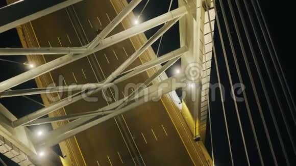 在现代城市的河上有夜间照明的缆车在有线电视桥上行驶视频的预览图