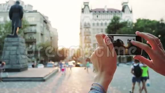 日落时分女性用智能手机在市中心拍照视频的预览图