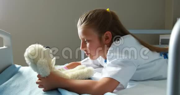 生病的女孩在床上玩玩具熊视频的预览图