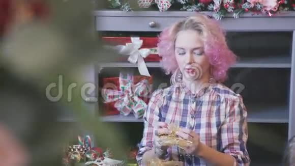 有粉色头发的女人为家里做圣诞装饰品视频的预览图
