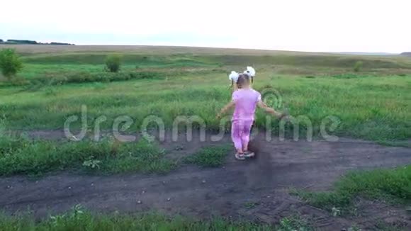 女孩训练他的腿小女孩训练踢腿她在绿色的草地上训练视频的预览图
