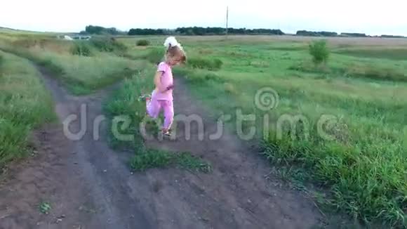 女孩训练他的腿小女孩训练踢腿她在绿色的草地上训练视频的预览图