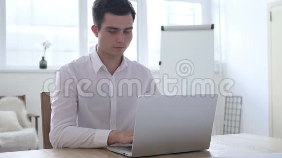 头痛穿着的商人在笔记本电脑上工作视频的预览图