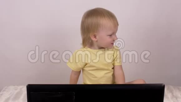 白种人小女孩金发碧眼看着笔记本电脑女性童年放松视频的预览图