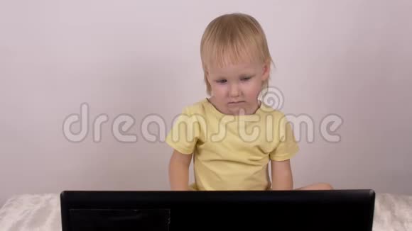 小白种人金发女孩看着笔记本电脑女性童年视频的预览图