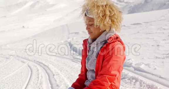 在白雪皑皑的小山上靠近快乐的女人视频的预览图
