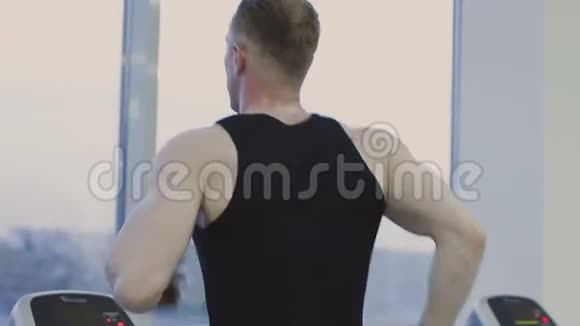 一个男人正在健身俱乐部的跑步机上练习视频的预览图