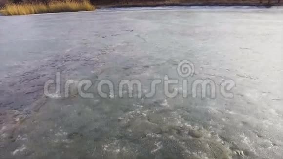 在阳光明媚的早春日鸟瞰冰冻湖泊的景观视频的预览图