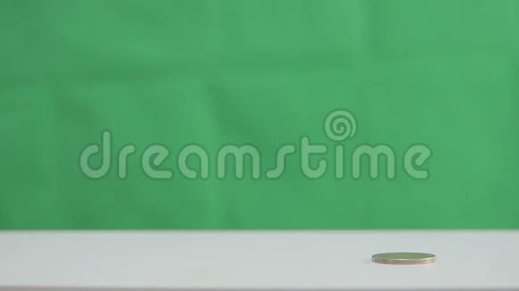 女人在绿叶背景上叠硬币的手视频的预览图