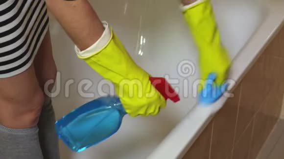 戴黄手套的女人洗干净的浴边视频的预览图