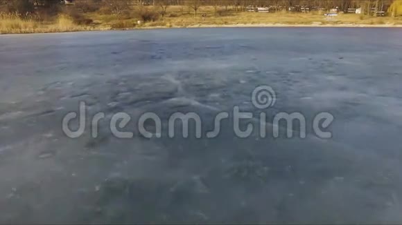 在阳光明媚的早春日鸟瞰冰冻湖泊的景观视频的预览图