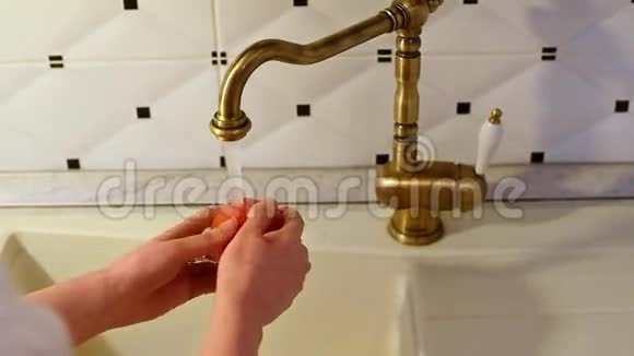 女子洗手台上的红番茄视频的预览图