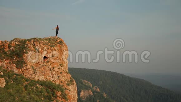 一个年轻的女人站在山顶上视频的预览图