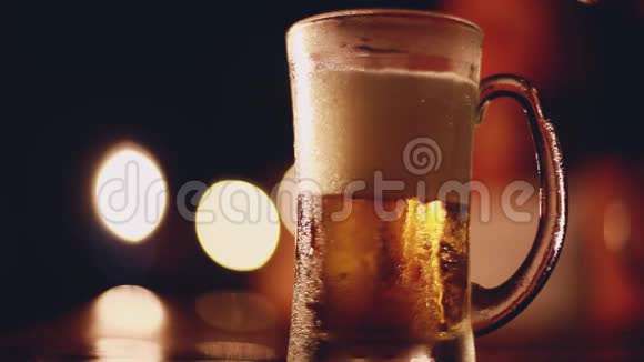 啤酒从瓶子里倒入玻璃一杯啤酒放在桌子上在酒吧或酒吧的玻璃上有凝结水视频的预览图