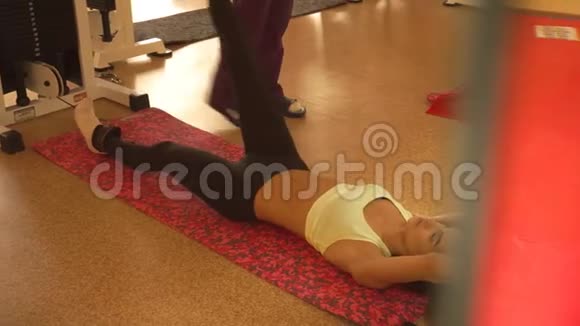 漂亮的运动女孩在地板上的健身房里练习视频的预览图