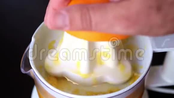 特写用榨汁机捏一个橘子视频的预览图
