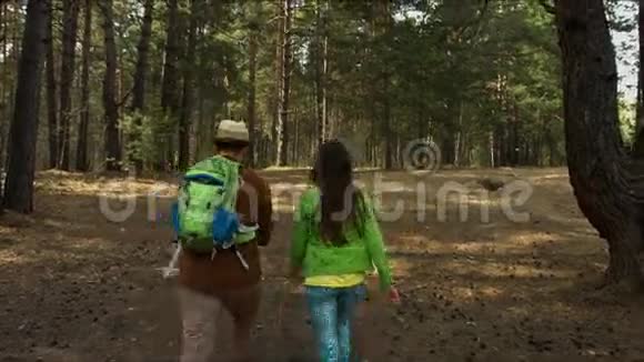 带着孩子的年轻家庭走在森林的小路上视频的预览图