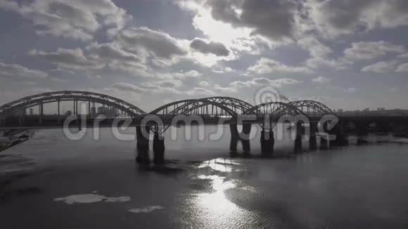 用空气拍摄铁路大桥附近汽车骑行河水被冰覆盖着阳光灿烂视频的预览图