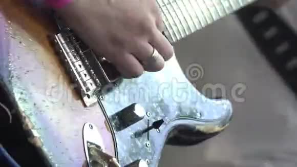 这位音乐家在摇滚音乐节上演奏一把老式电吉他双手特写视频的预览图