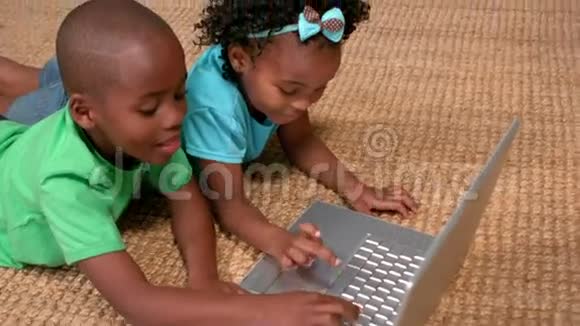 孩子们在地板上使用笔记本电脑而父母则在看视频的预览图