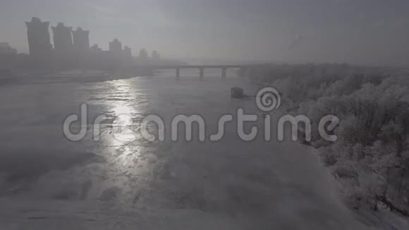 飞过冰封的河水远处可见城市视频的预览图