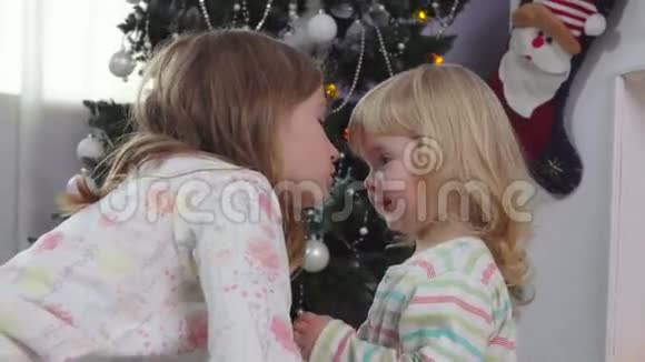 小女孩在圣诞树附近挑选礼物视频的预览图