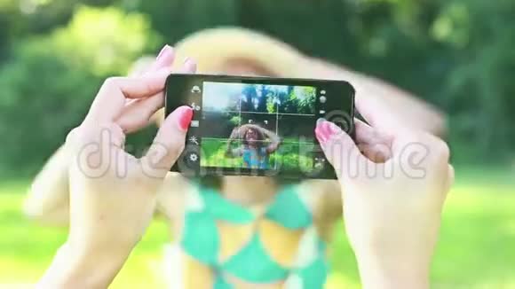 年轻女子用电话给朋友拍照视频的预览图