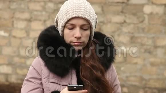 女人在智能手机上写冬装短信视频的预览图