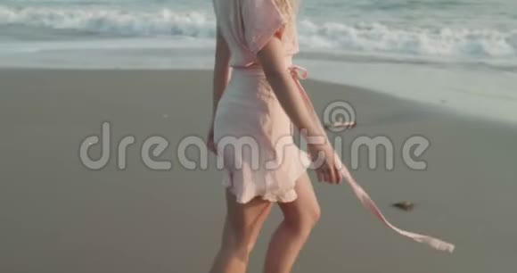 穿着漂亮的女孩在沙滩上放松视频的预览图