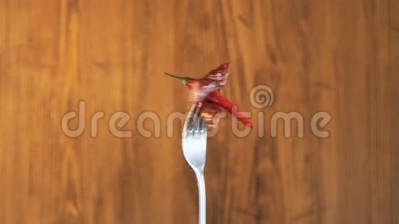 木制背景下两个香肠和辣椒旋转叉子视频的预览图
