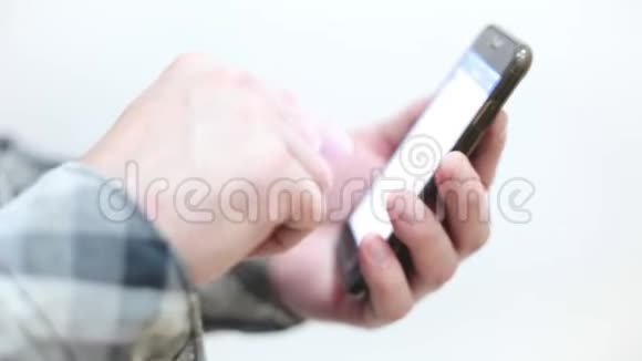 穿格子衬衫的时髦年轻人用智能手机视频的预览图
