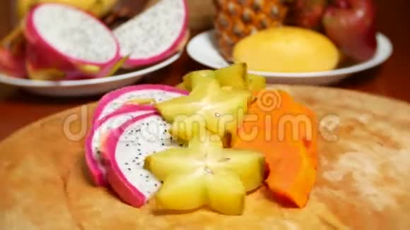 餐桌上的异国水果4k杨桃和火龙果木瓜西番莲水果切成块旋转在一个视频的预览图