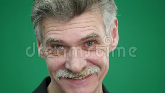 老人在绿色背景下笑的肖像视频的预览图