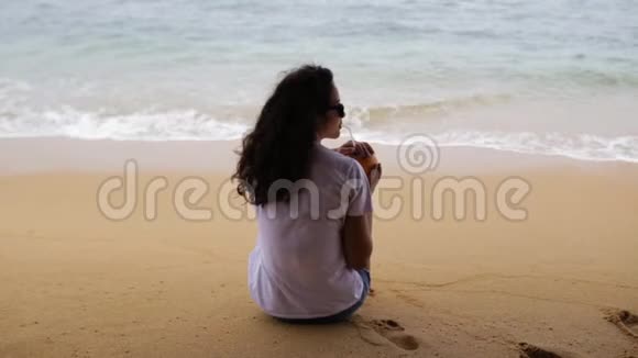 女孩在海滩上喝鸡尾酒视频的预览图
