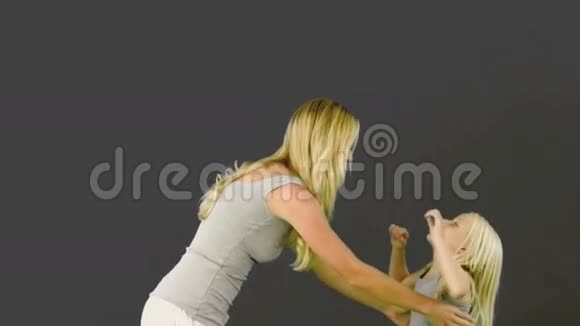 母亲把女儿抱在灰色的背景上视频的预览图