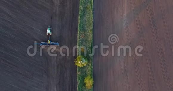 日落时种植小麦的拖拉机的俯视图视频的预览图