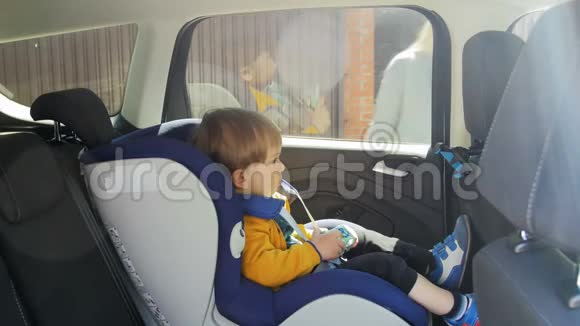 坐在儿童车安全座椅上的可爱男婴4k视频视频的预览图
