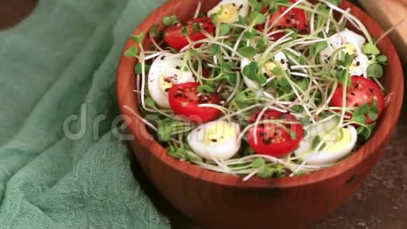木碗里放有萝卜芽鹌鹑蛋樱桃番茄和芝麻的清淡沙拉视频的预览图