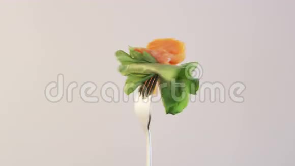 在杏仁背景上用鲑鱼和生菜旋转叉子视频的预览图