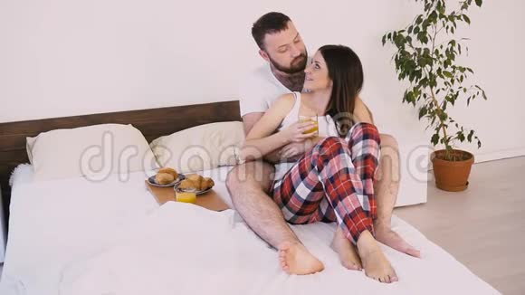 一男一女早上醒来在床上吃早餐视频的预览图