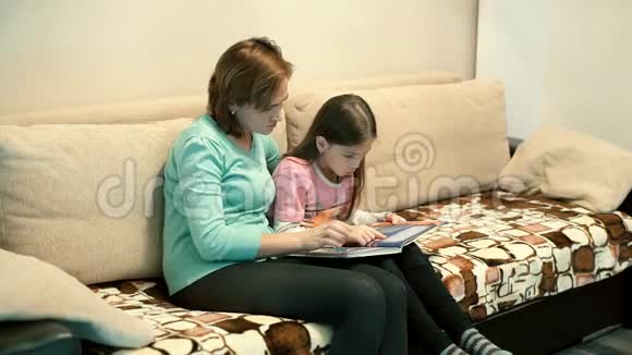 妈妈和女儿坐在沙发上看书视频的预览图