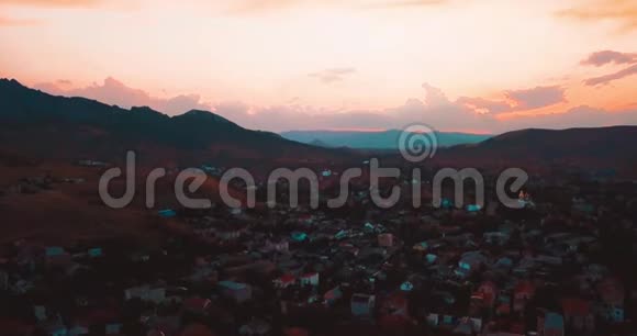 山峰日落海和城市山谷边缘的史诗岩石和太阳耀斑4k无人驾驶飞机视频的预览图