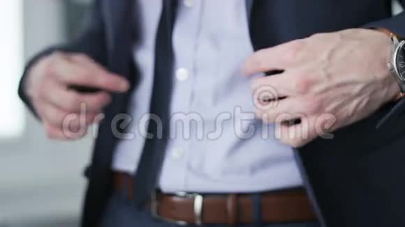 商人扣紧他的夹克在他的手表上计时视频的预览图